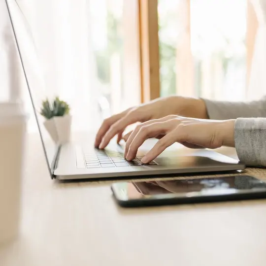 Business woman hand typing laptop computer on wooden table