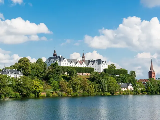 Plöner Schloss vom Wasser - Ausflugsziel beim Bauernhof-Urlaub - © penofoto.de, AdobeStock Fotos einer Bootsfahrt auf dem Großen Plöner See ein unter Naturschutz stehender See in Schleswig-Holstein.