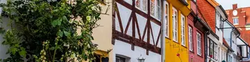 Idyllischer Hof mit bunten historischen Häusern und Pflanzen in der Lübecker Altstadt