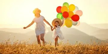 happy family mother and child with balloons at sunset in summer happy family mother and child daughter with balloons at sunset in summer