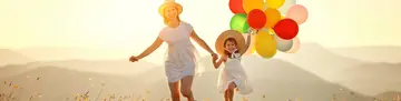 happy family mother and child with balloons at sunset in summer happy family mother and child daughter with balloons at sunset in summer