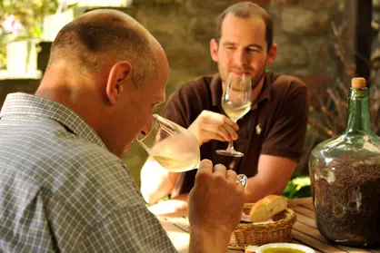 zwei Männer sitzen im Hof bei der Weinprobe