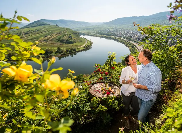 Weinprobe im Weinberg - © Rheinland-Pfalz Tourismus GmbH, Dominik Ketz im Urlaub auf dem Weingut an der Mosel eine Weinprobe mit Blick auf die Moselschleife bei Bremm genießen