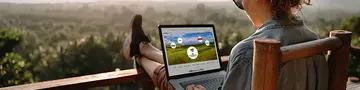 Frau auf Terasse mit Blick über Wald arbeitet an Laptop. Auf dem Bildschirm sieht man symbolisch die Anbindemöglichkeiten mit Ical. 