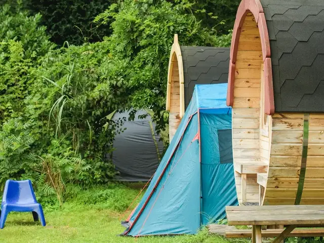 Holz-Weinfass als Ferienunterkunft mit Terrasse und Blick auf einen Teich im Grünen