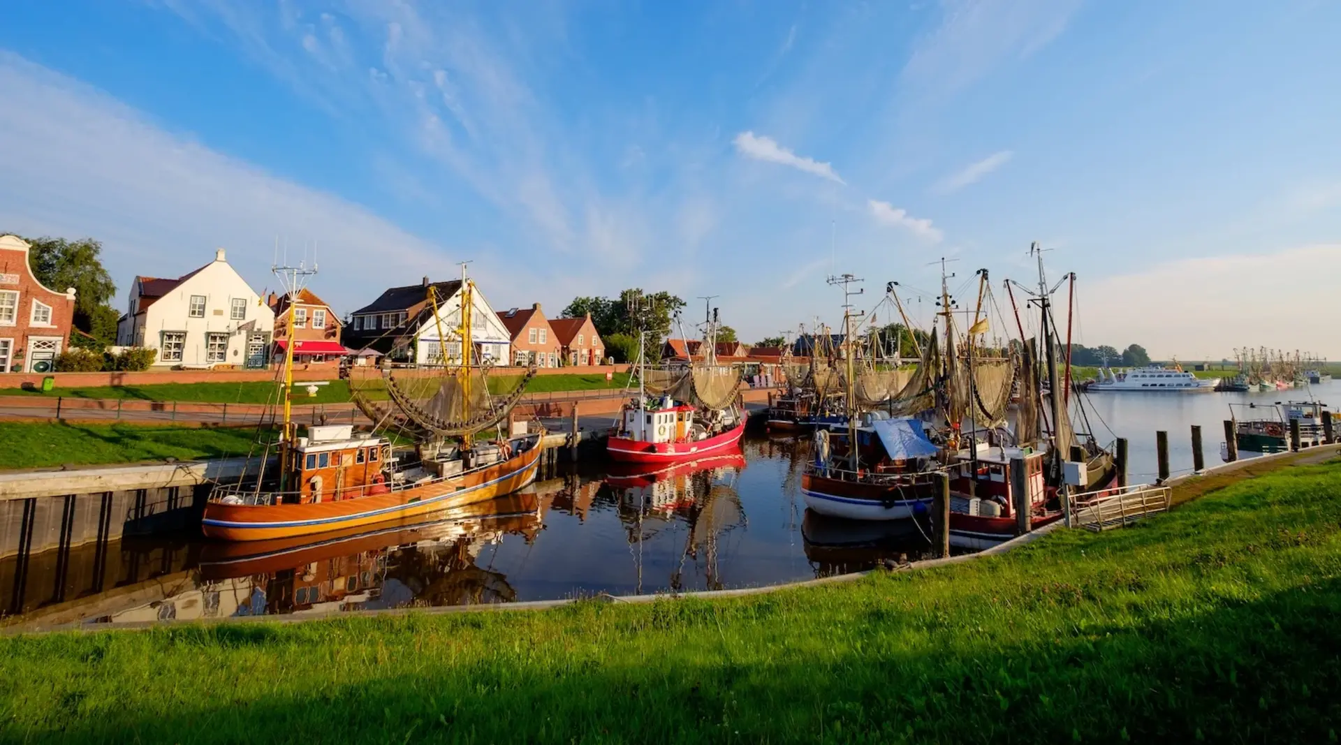 Der Kutterhafen von Greetsiel am Morgen mit vielen bunten Fischerboten. 