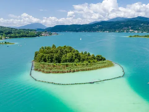 alt="Blau-türkiser Bergsee im Herbst mit Silberdistel im Vordergrund."