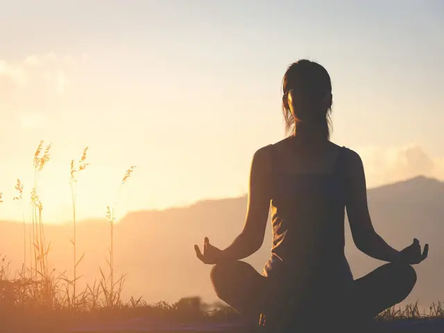Zeit für Ruhe und Entspannung auf dem Land - © nakedcm, adobe stock Person meditiert in der Natur bei Sonnenuntergang
