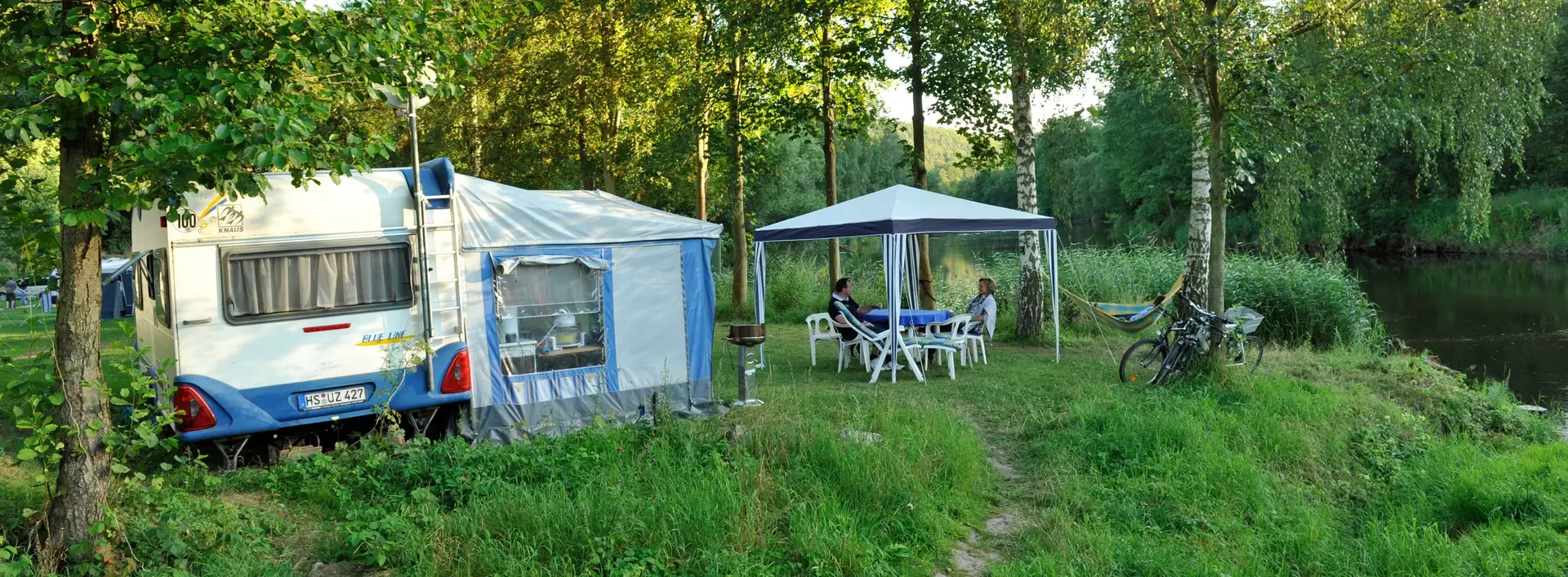 Wohnmobil auf Campingplatz im Grünen im Sommer auf dem Land