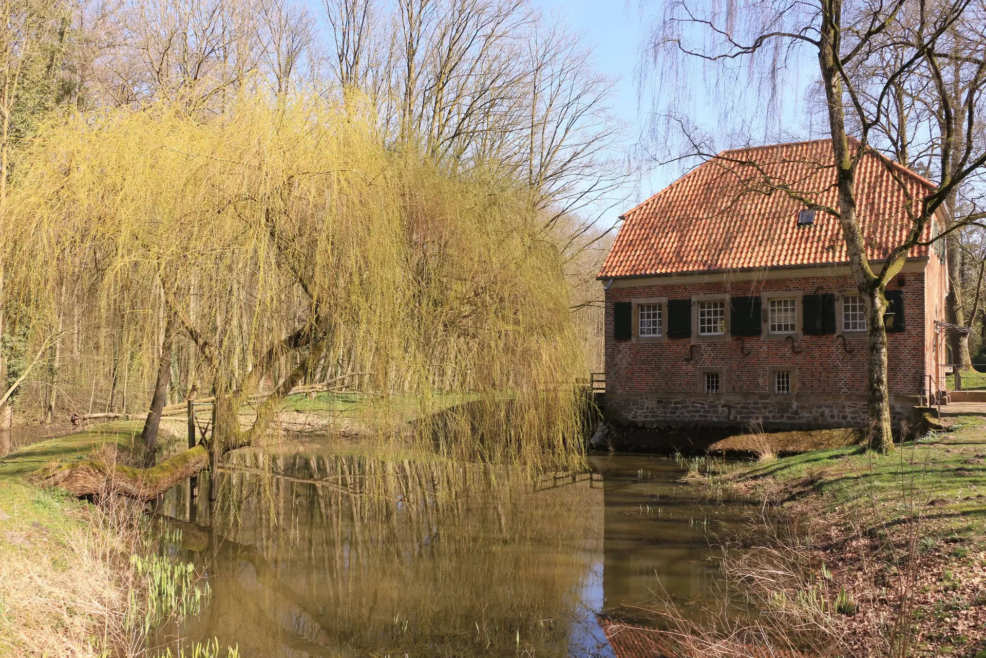 Historisches Gebäude an einem kleinen See auf dem Gelände von Kloster Dinklage