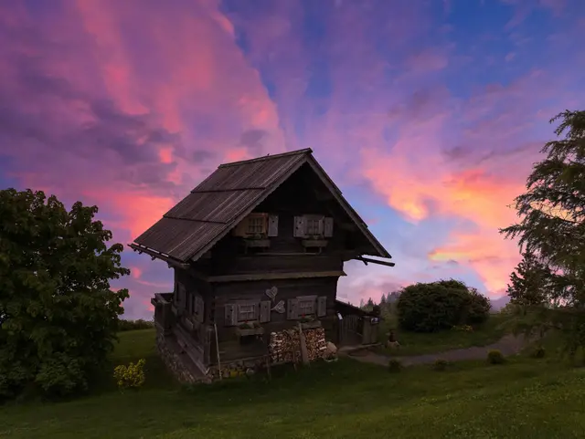 Almhütte in Kärnten – Urlaub auf dem Land in Österreich - © TomKlar, AdobeStock Rustikale Almhütte in Kärnten vor einem farbenfrohen Abendhimmel – Urlaub auf dem Land in Österreich.