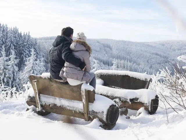 Ein Paar geniesst die Aussicht über den verschneiten Thüringer Wald.