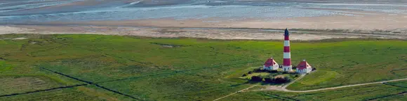 Blick über die Salzwiesen auf die Nordsee mit dem Leuchtturm von Westerhever, Schleswig-Holstein