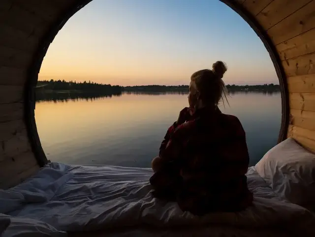 Silhouette eines Paares im Weinfass mit Blick auf einen See bei Sonnenuntergang