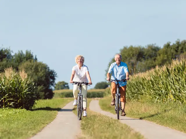 Gemeinsam aktiv unterwegs – Urlaub auf dem Land genießen - © Kzenon, adobe stock Ein älteres Ehepaar fährt mit dem Fahrrad über das Land