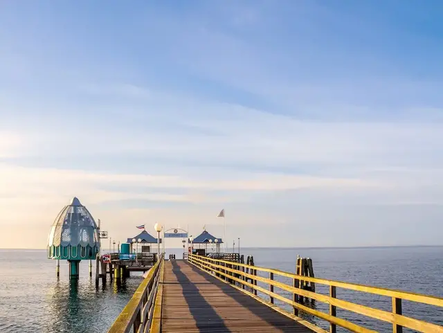 Die Seebrücke in Grömitz erstreckt sich im warmen Morgenlicht über die ruhige Ostsee.