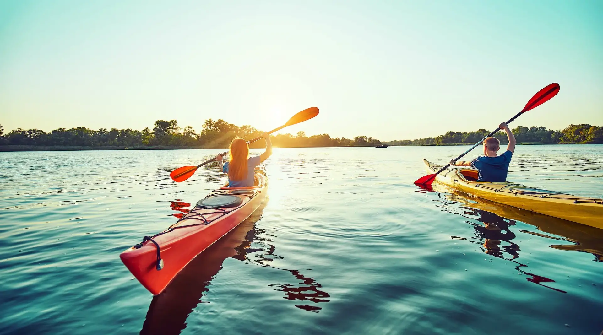 Kajakfahrer auf einem See bei Sonnenuntergang