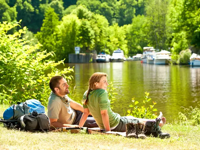 Paar entspannt bei einer Wanderpause an der Lahn