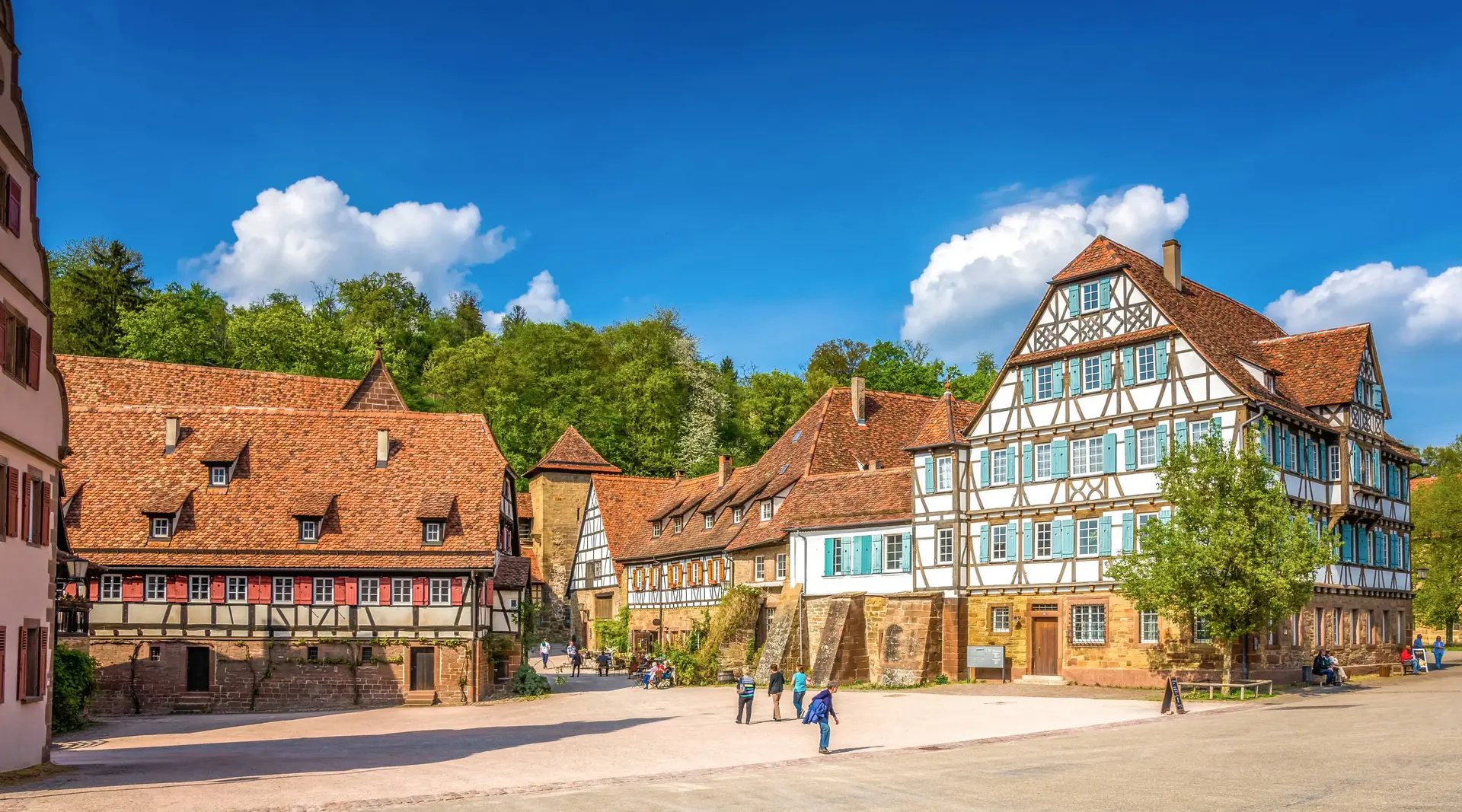 Kloster Maulbronn – UNESCO-Welterbe in Baden-Württemberg - © Kloster Maulbronn, Adobe Stock Historische Fachwerkgebäude im Kloster Maulbronn unter blauem Himmel in Baden-Württemberg.
