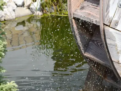 Wasserrad einer Getreidemühle - © Urlaub in Mühlen: Technik erleben, Wasserrad dreht sich im Wasser