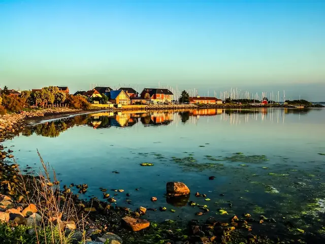 Häuser am Hafen und Bucht im Abendhimmel – Ferienwohnung auf Fehmarn Häuser am Hafen und an der Bucht von Fehmarn sind unter einem stimmungsvollen Abendhimmel zu sehen.