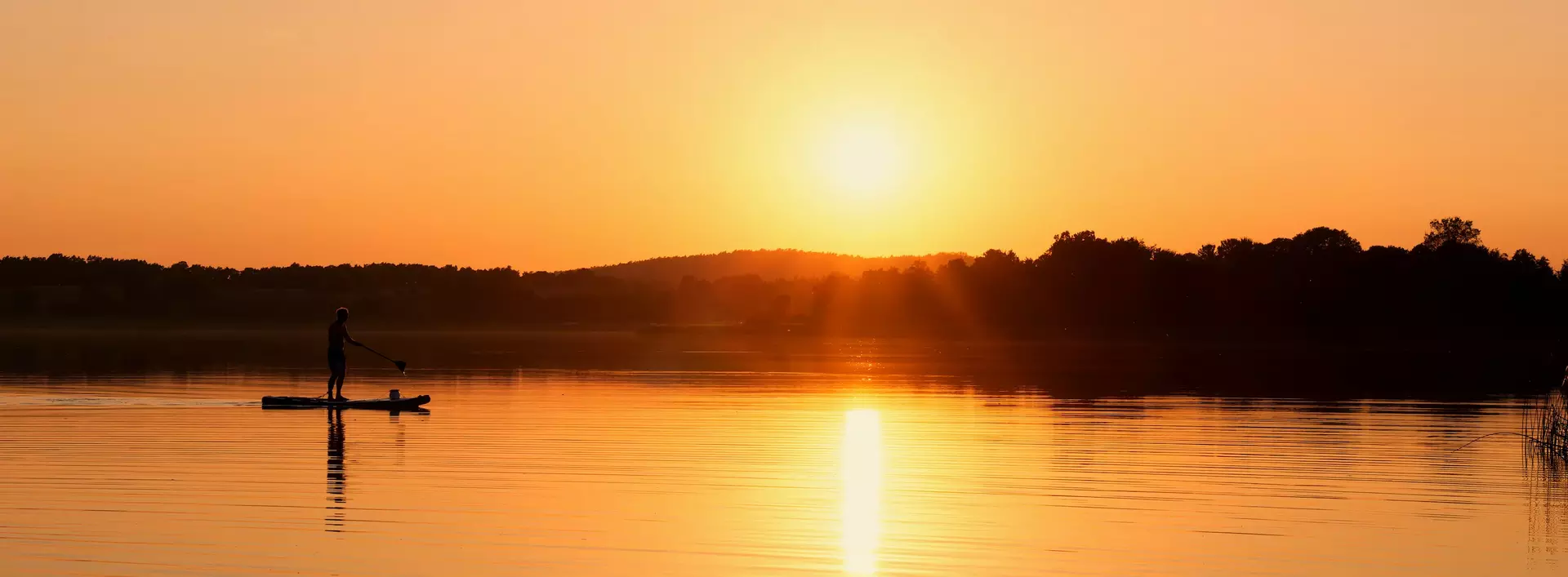 Idyllischer Sonnenuntergang in der Uckermack mit SUP-Fahrer