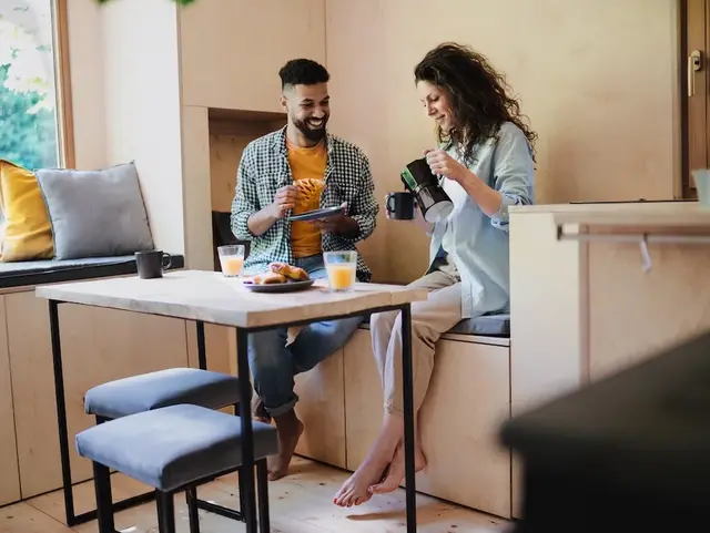 Pärchen sitzt im Tiny House und Frühstückt.