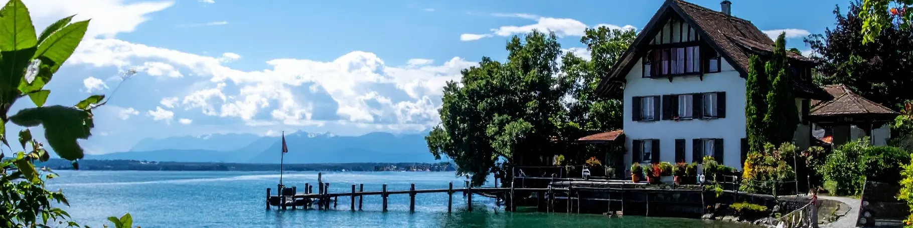 Ferienhaus direkt am Bodensee im Hintergrund sieht man Wolken und Berge.