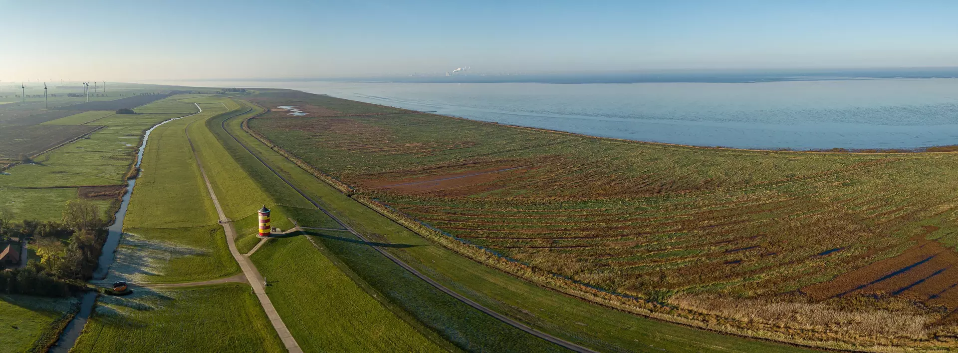 Blick von oben auf den Nordseedeich mit dem Pilsumer Leuchtturm, Ostfriesland