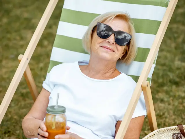 Beautiful senior woman in white lying on the sunbed, relaxing in the park. Concept of rest and carefree life on retirement Beautiful senior woman in white lying on the sunbed, relaxing in the park. Concept of rest and carefree life on retirement
