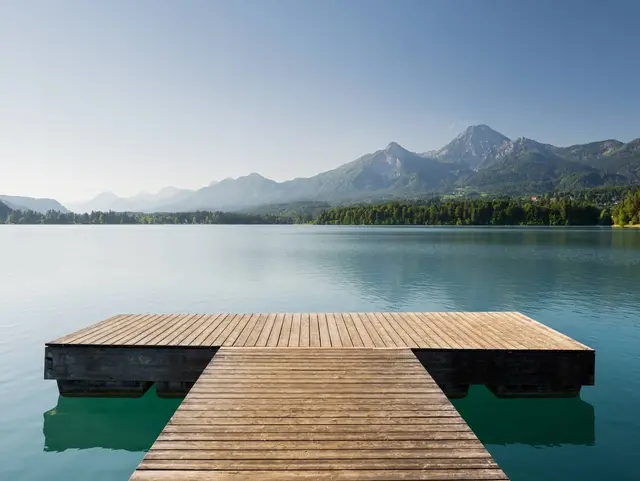 Steg am Faaker See in Drobollach – Urlaub auf dem Land in Kärnten - © Rainer Mirau, AdobeStock Holzsteg am Faaker See bei Drobollach mit Blick auf den Mittagskogel in Kärnten – Urlaub auf dem Land in Österreich.