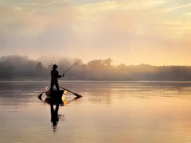 Angeln am See am Morgen in ruhiger Landschaft - © andrii27, adobe stock Angler auf einem ruhigen See bei Sonnenaufgang