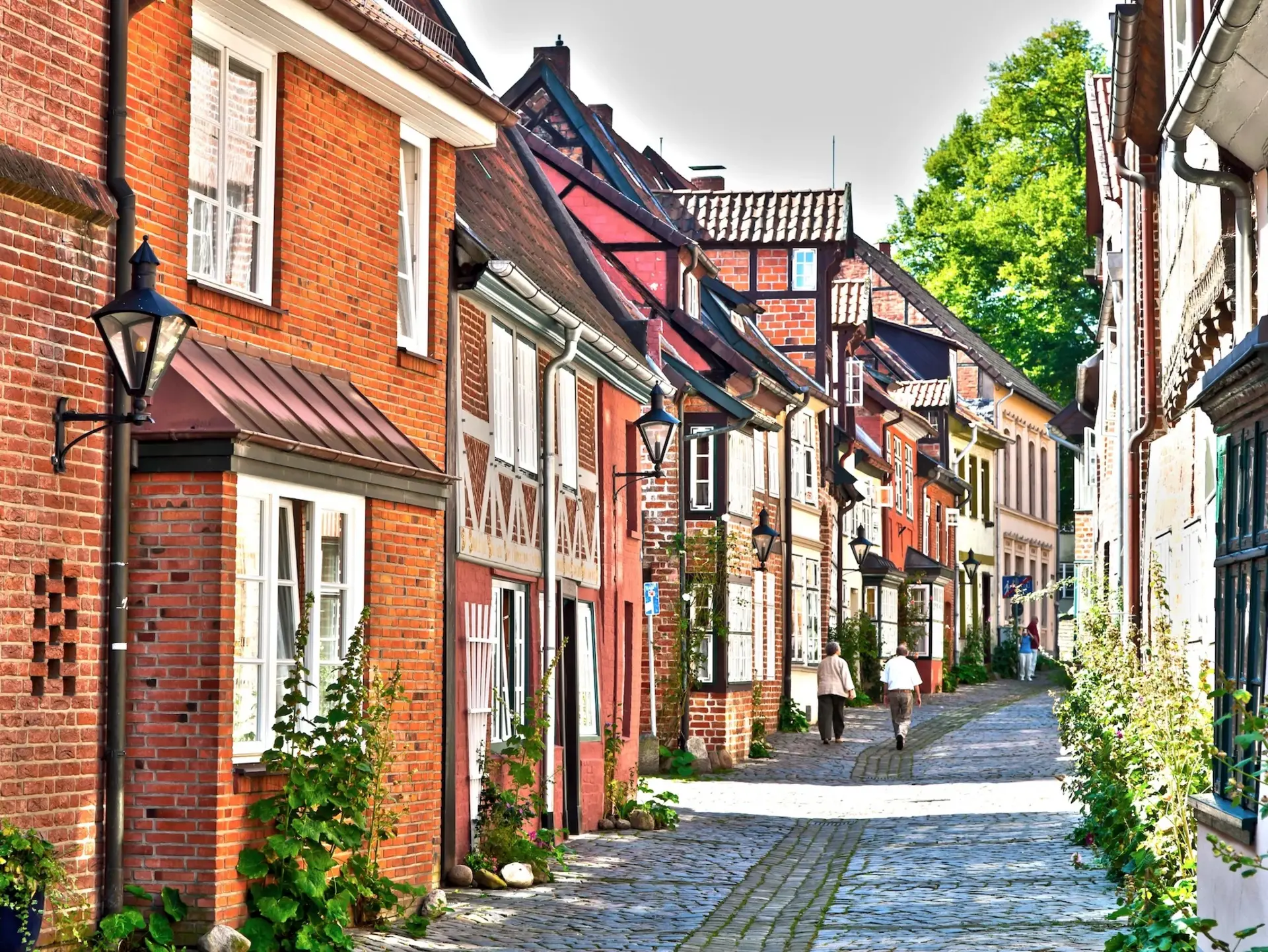 Fachwerkgassen in Lüneburg Zeigt eine Gasse mit alten Häusern im Fachwerk und Blumen.