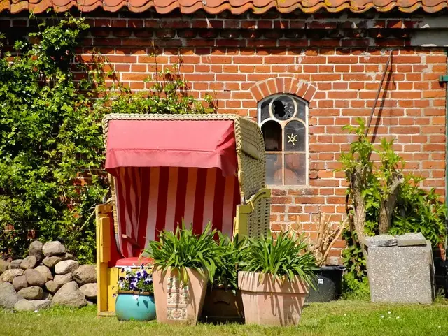 Entspannter Urlaub im Strandkorb in der holsteinischen Schweiz - © druckingenieur – stock.adobe.com Ein Gelber Strandkorb steht im Garten vor einer schönen Backsteinmauer in der holsteinischen Schweiz.