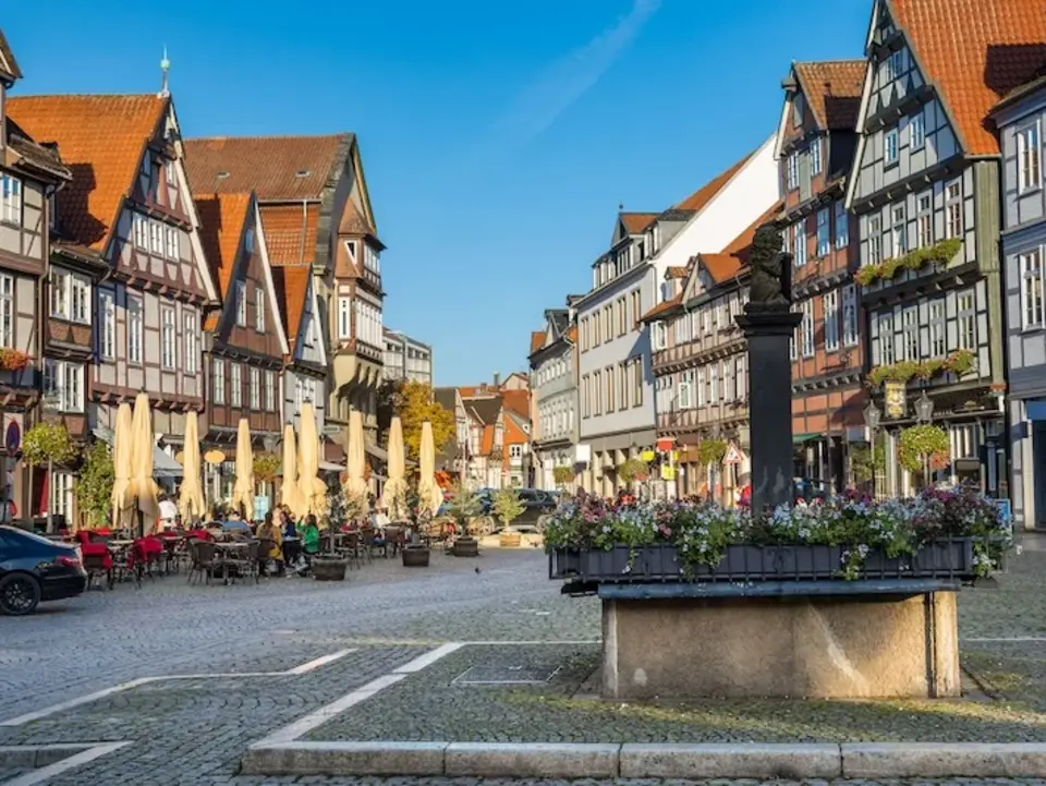 Charmante Fachwerkhäuser in der Altstadt von Celle, gesäumt von gemütlichen Cafés mit Außensitzplätzen, die zum Verweilen einladen – eine lebendige Atmosphäre zwischen historischer Architektur und modernem Stadtleben.