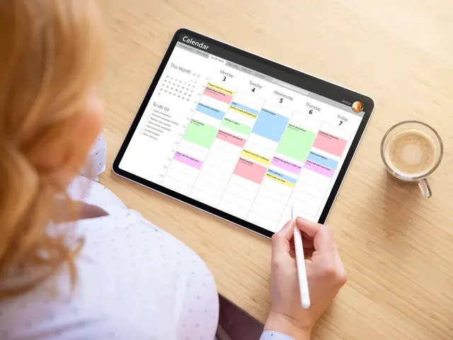 Woman using calendar app on tablet computer for appointment and task management Woman using calendar app on tablet computer for appointment and task management