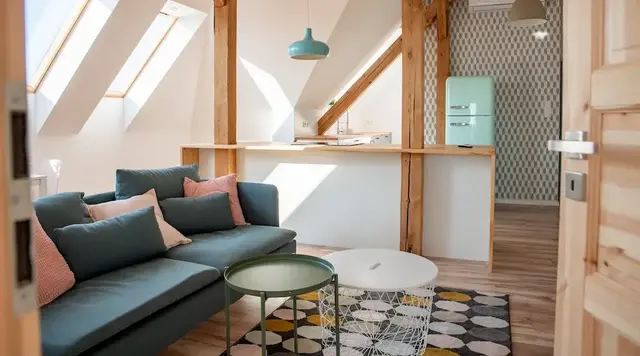 Gemütlich eingerichtete Ferienwohnung mit sichtbaren Holzbalken, die eine warme und naturnahe Atmosphäre inmitten ländlicher Umgebung ausstrahlt. 