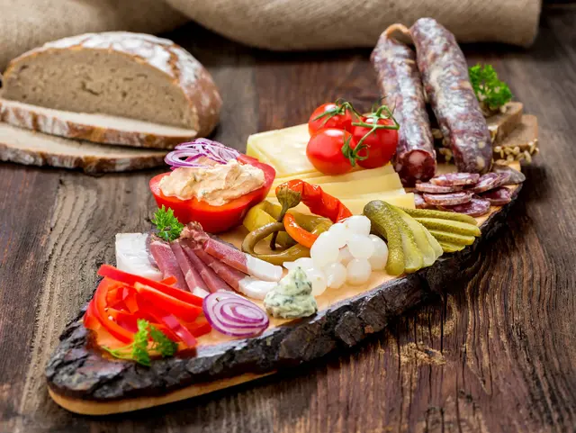Kärntner Jause genießen – Regionaler Genuss auf dem Bauernhof - © Lumixera, AdobeStock Traditionelle Kärntner Jause mit regionalem Brot, Käse, Speck, Wurst und Hofprodukten auf einem Bauernhof in Kärnten.