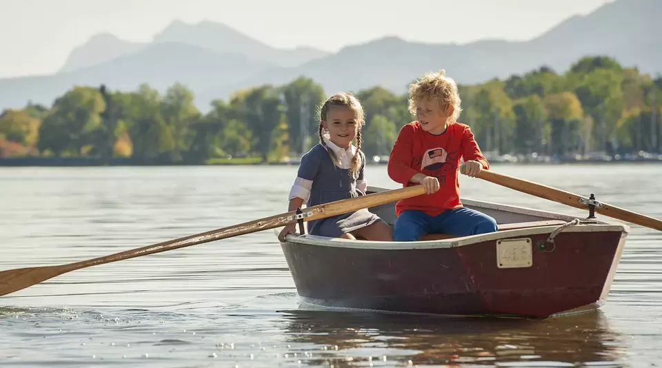 Kinder im Ruderboot auf dem Chiemsee - © , Chiemsee-Alpenland Tourismus im Familienurlaub auf dem Bauernhof am Chiemsee entdecken Kinder im Ruderboot den See