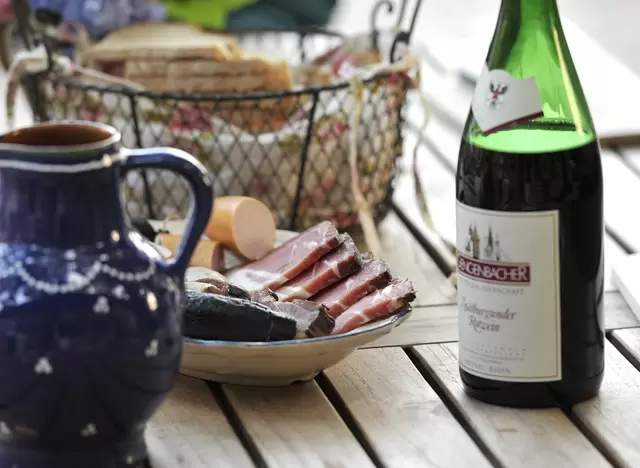 im Urlaub am Kaiserstuhl zu einer Winzervesper mit Wurst und Wein auf dem Weingut einkehren