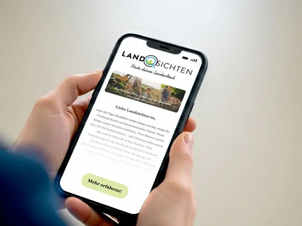 Zwei Hände halten ein Smartphone mit dem Landsichten Newsletter voller Inspirationen für Urlaub auf dem Land.