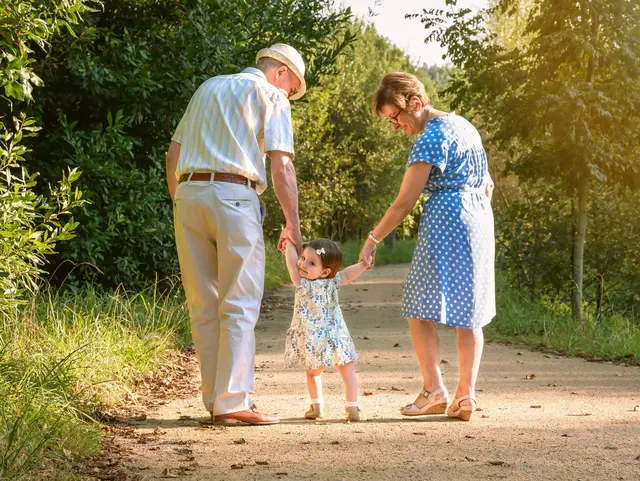 Grandparents and baby grandchild walking outdoors Back view of grandparents and baby grandchild walking on a nature path