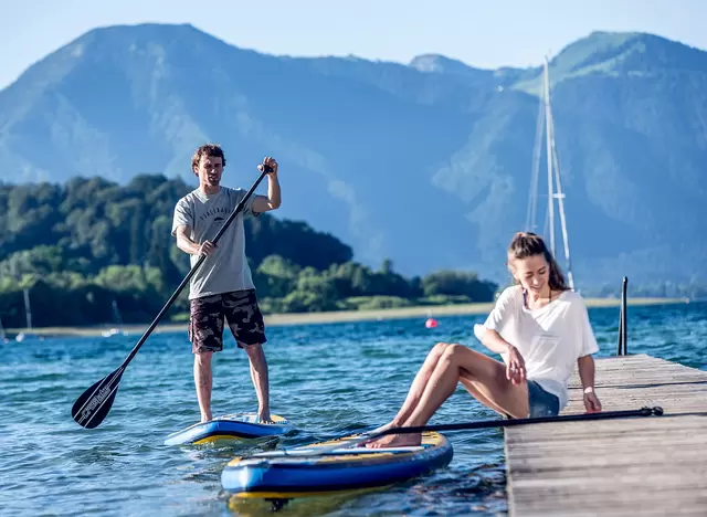 im Urlaub am Tegernsee Wassersport wie Stand Up Paddeling oder Segeln betreiben
