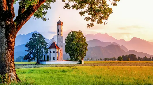 Die Kirche Sankt Coloman in Schwangau im Ostallgäu in Bayern im stimmungsvollen Abendlicht. 