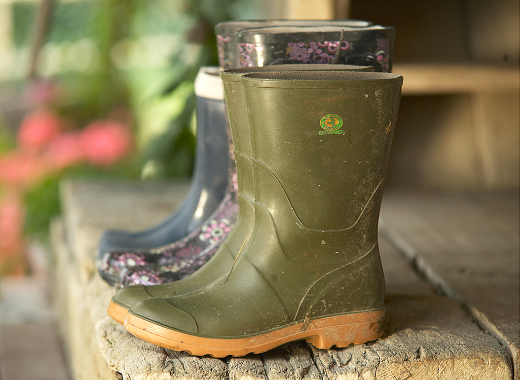 Gummistiefel auf dem Bauernhof, Blauer Gockel im Bauernhofurlaub bei der Hofarbeit mithelfen
