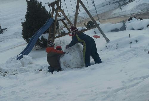 Kinder beim Schneemann bauen