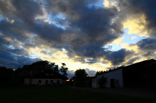 Sonnenuntergang mit Wolken ueberm Dannerbauerhof