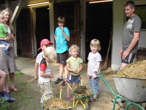 Kinder bei der Stallarbeit