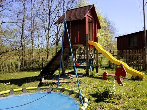 Spielplatz mit Schaukel, Wippe, Rutsche und Sandkasten mit Blick zu den Ponys