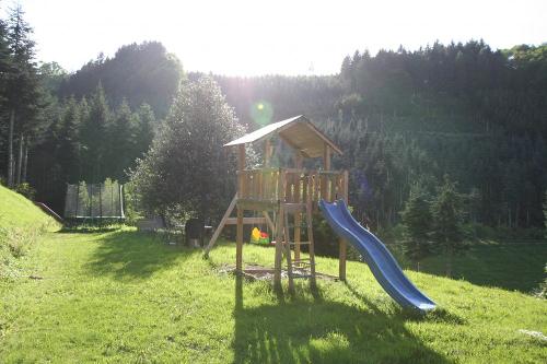 Spielplatz mit Spielhaus, Rutsche, Schaukeln, Sandkasten und Riesentrampolin